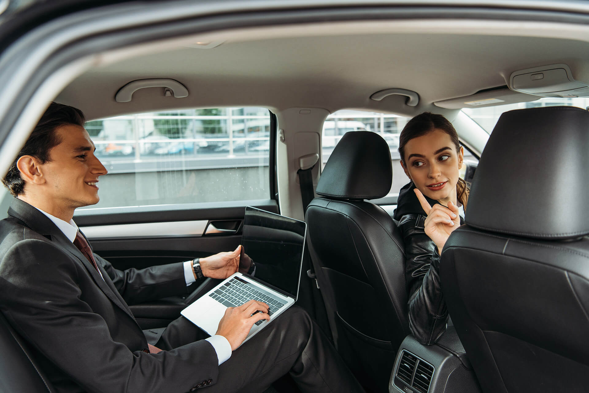 driver-talking-to-businessman-with-laptop-in-taxi-2022-12-16-19-53-13-utc.jpg